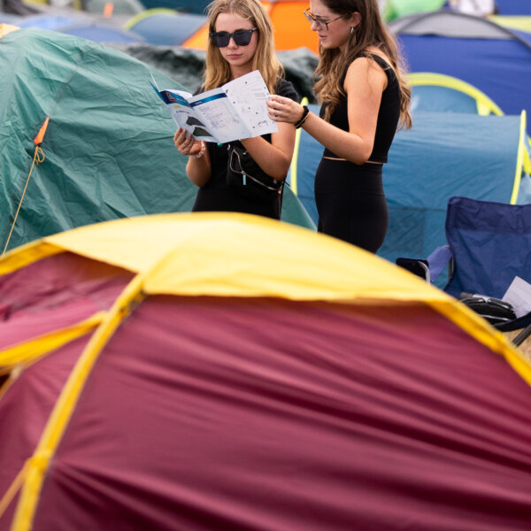 Two people reading tent set up instructions